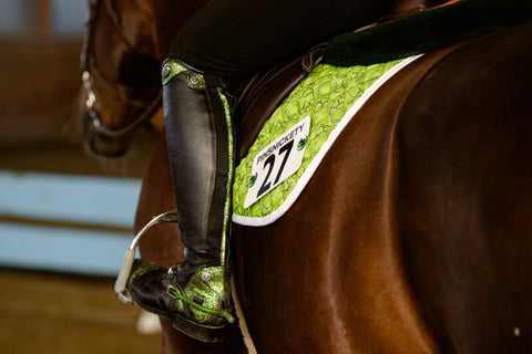 pinsnickety horseshoe horse show number pins on a green saddle pad with matching green boots