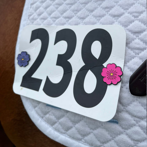 pinsnickety poppy horse show number pins a saddle pad, featuring one in purple and one in pink