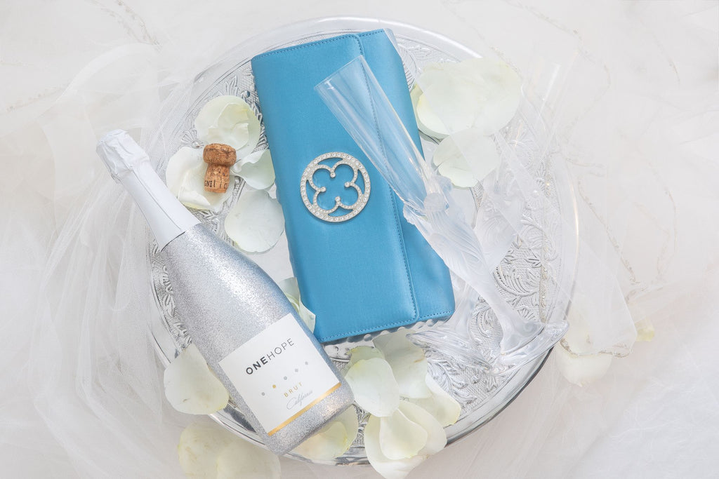 Blue bridal clutch with champagne on the table