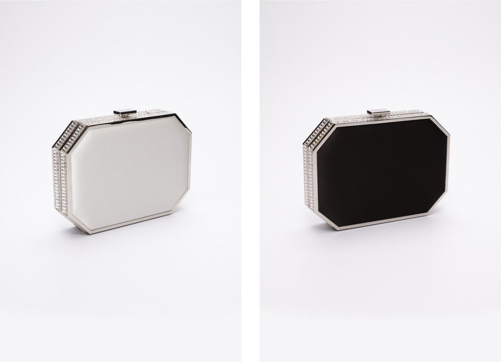 To Como clutches side-by-side. One Como clutch is in white satin, the second Como clutch is in black satin.