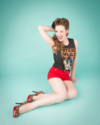 Casey in a classic pinup pose against a light blue background