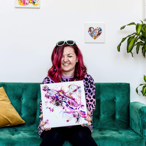 Artist laughing with artwork in hand