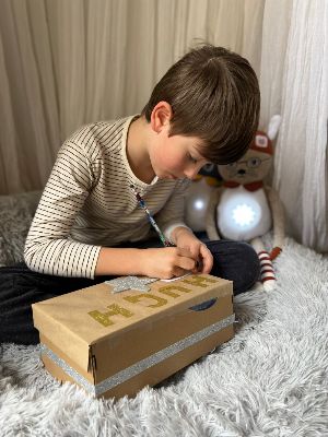 Boy writing out worries for worry box with Brave and Able