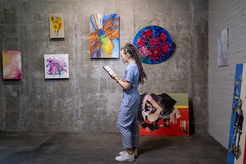 a girl satnding in a room with paintings