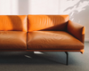 Light brown boned leather sofa partially covered in sunlight.