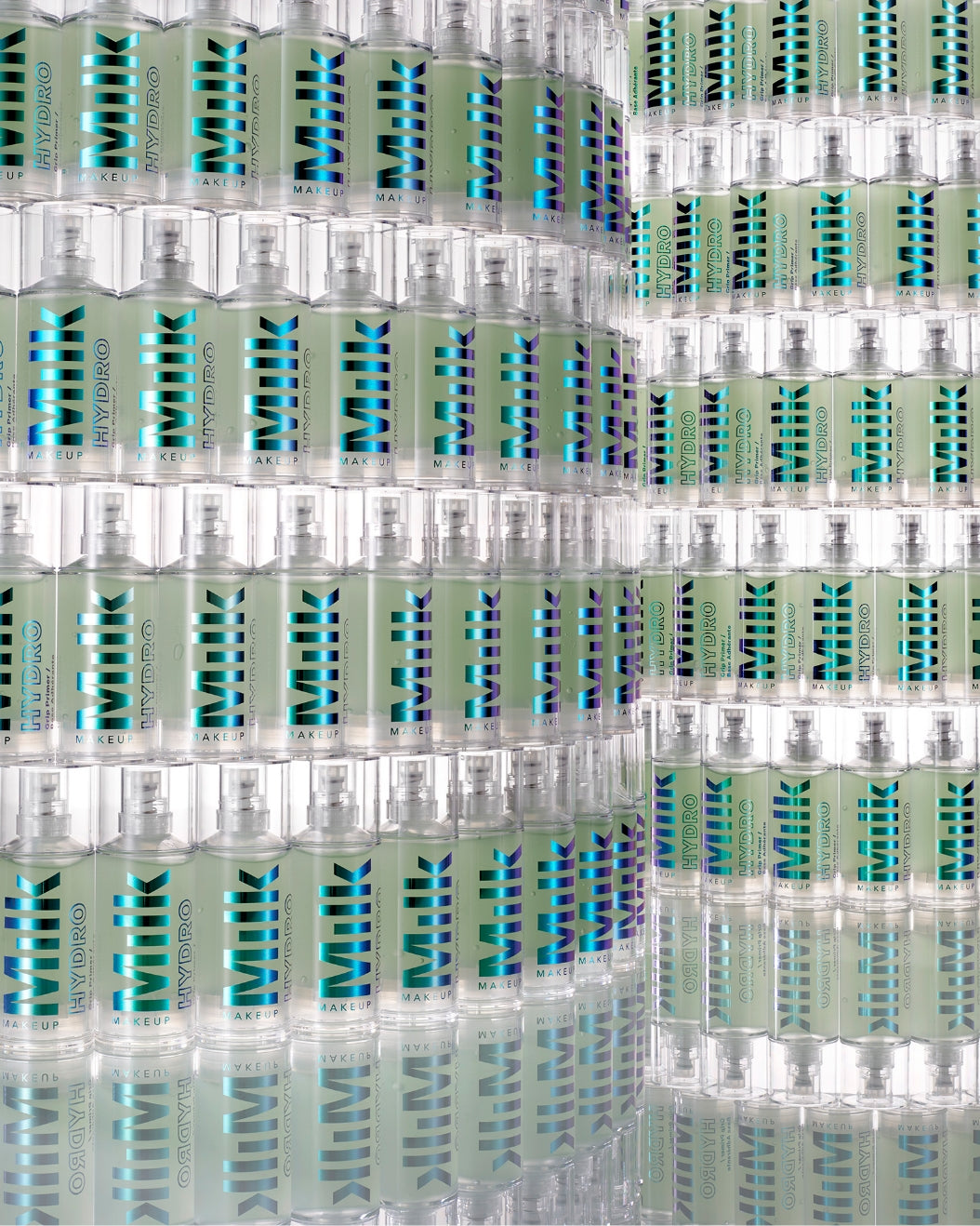 A large amount of Hydro Grip Primer bottles stacked on shelves against a white background