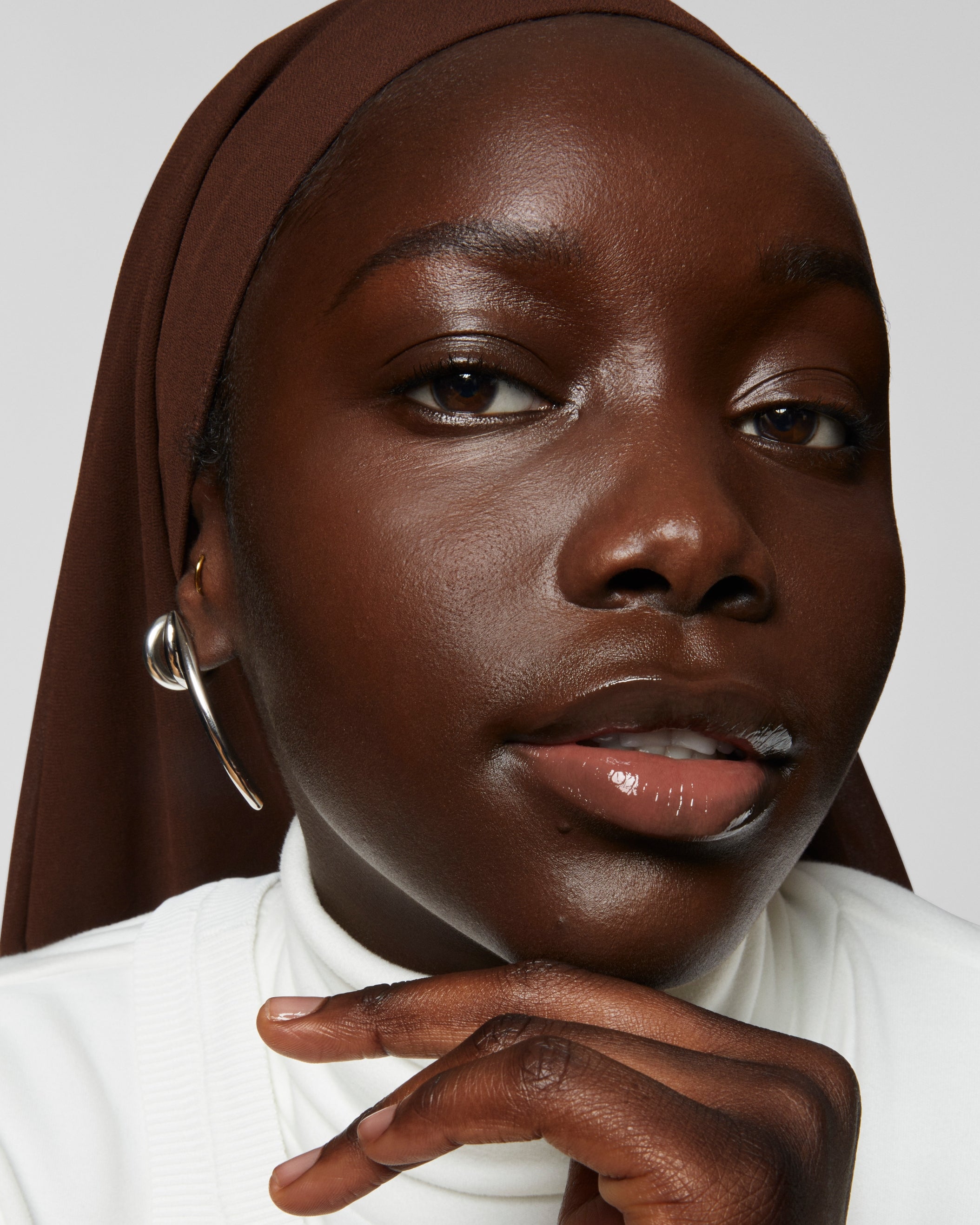 Model wears Milk Makeup Future Fluid All Over Cream Concealer in 29N on a white background