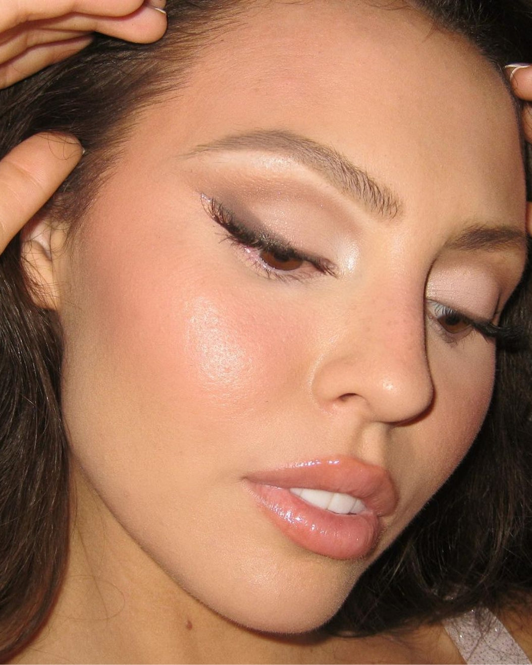 Model wears neutral smoky cat-eye makeup for holiday makeup inspiration