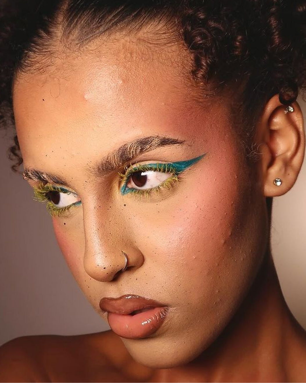 Model wears colorful eye makeup with colorful eyelashes for holiday makeup inspiration