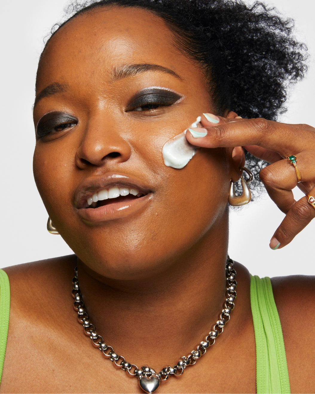 Model applies a swipe of Milk Makeup Hydro Ungrip Makeup Removing Cleansing Balm on a white background