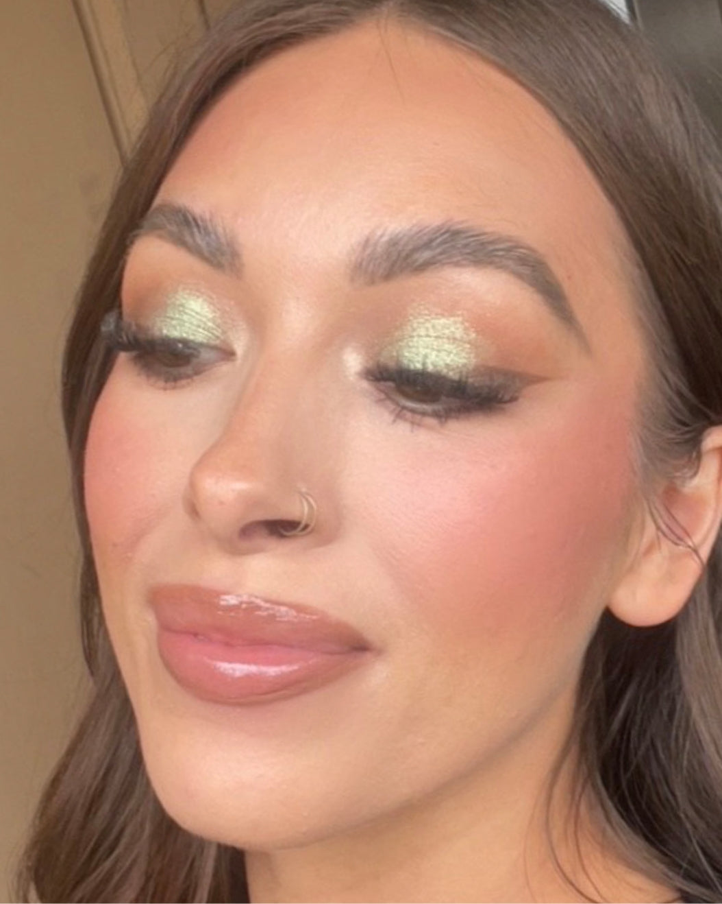 Makeup Artist wears a matcha latte-inspired makeup look with light green shimmer eyeshadow.