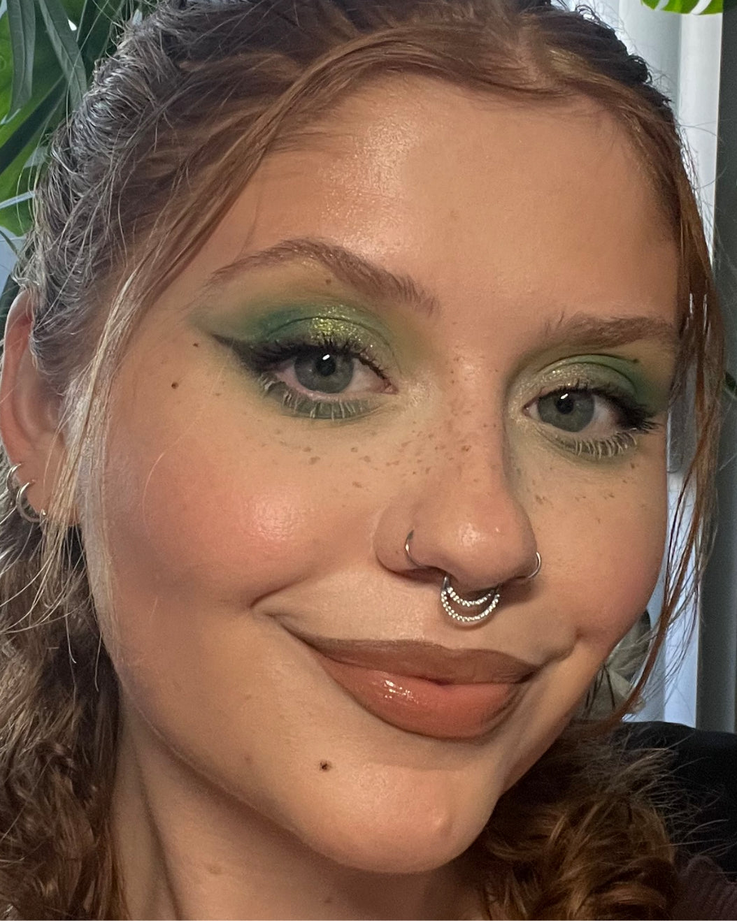 Makeup artist wears a matcha latte-inspired makeup look with shimmery green eyeshadow and nude-brown lips