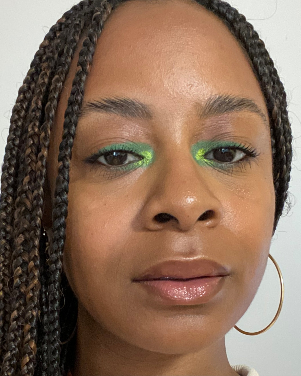 model wears a matcha latte-inspired makeup look with green eyeshadow in the corner of her eyes