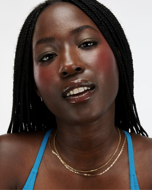 Model wears Milk Makeup Lip + Cheek in Flip on a white background.