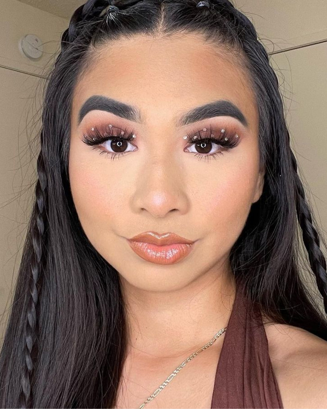 Portrait of a woman with brown eyeshadow and rhinestones to use for holiday makeup inspiration