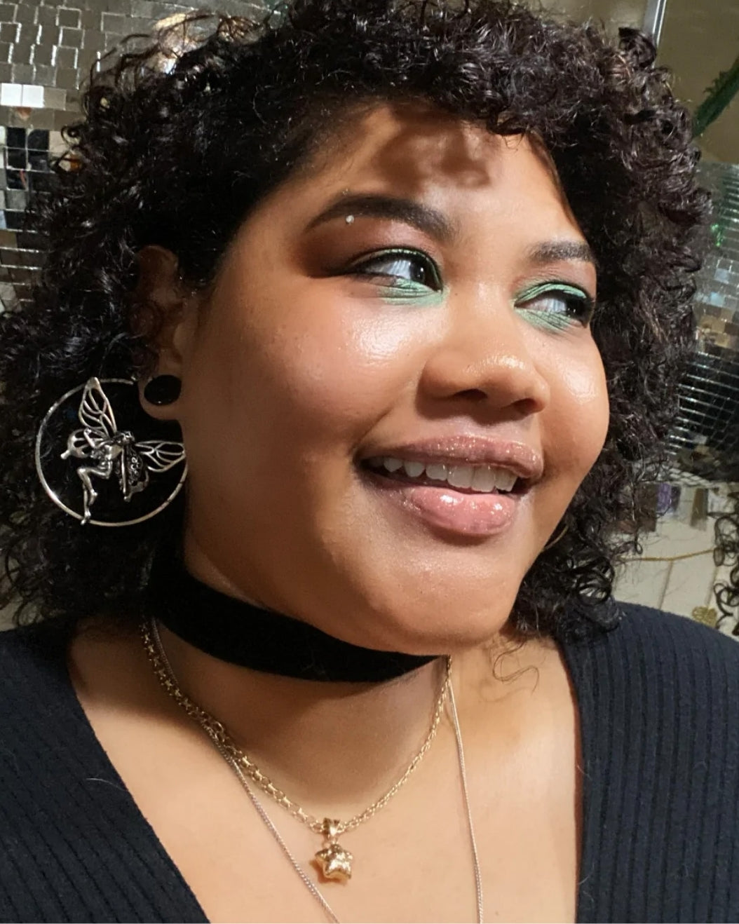 Portrait of a woman with green and brown eyeshadow to use as holiday makeup inspiration