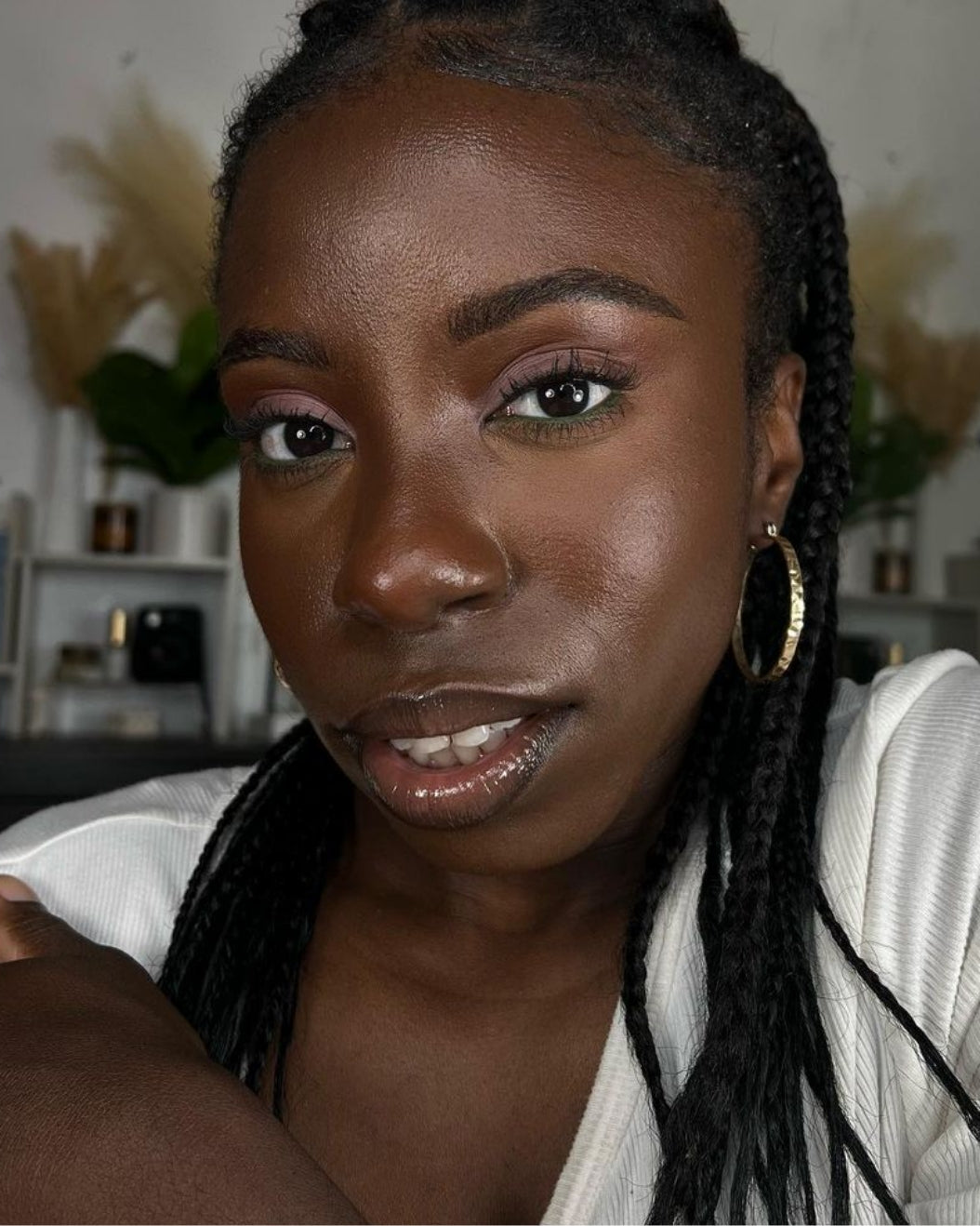 Portrait of a woman with neutral eyeshadow and green liner in her waterline as part of holiday makeup inspiration