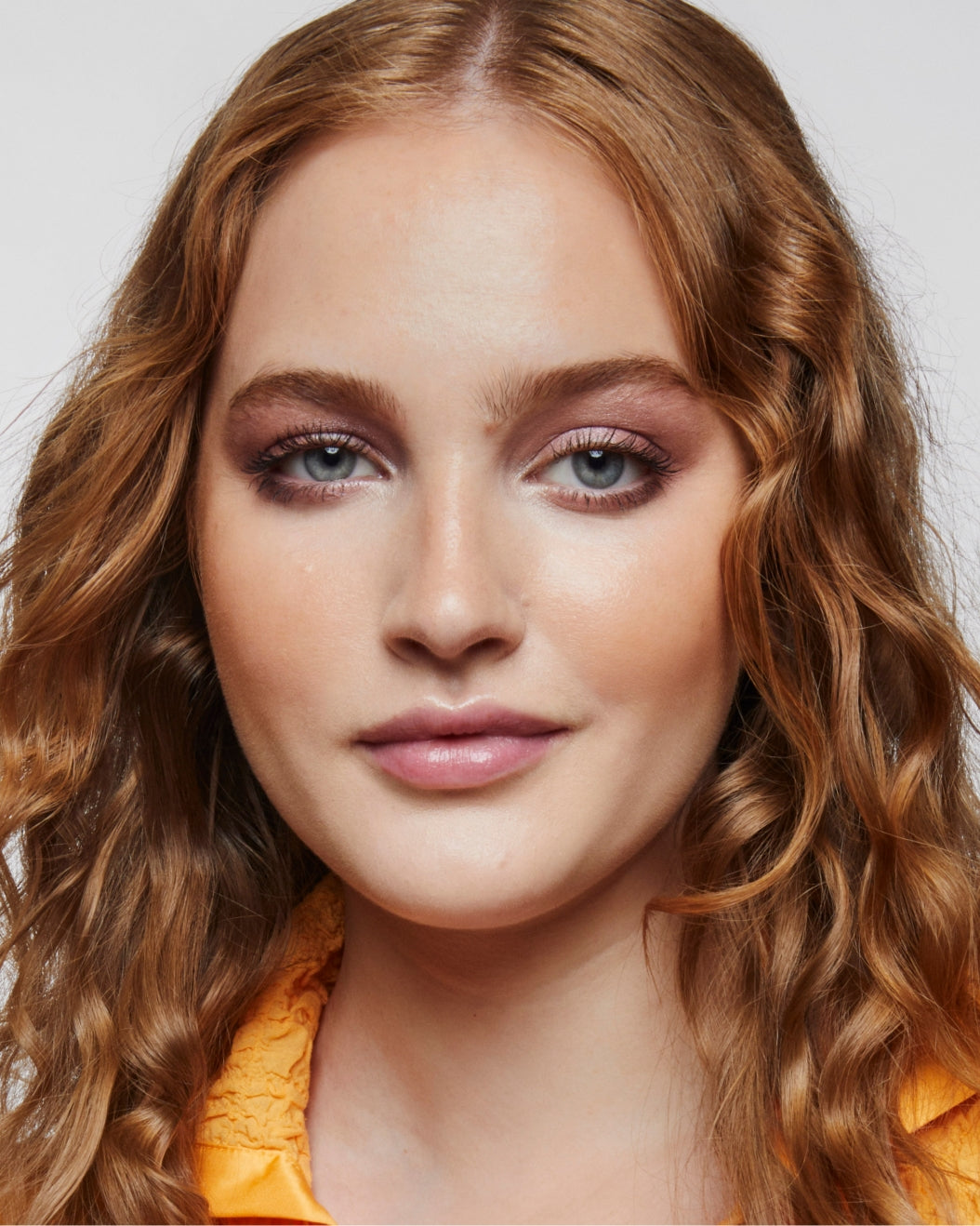 Model wears a full face of Milk Makeup products including Matte Bronzer and Lip + Cheek against a white background