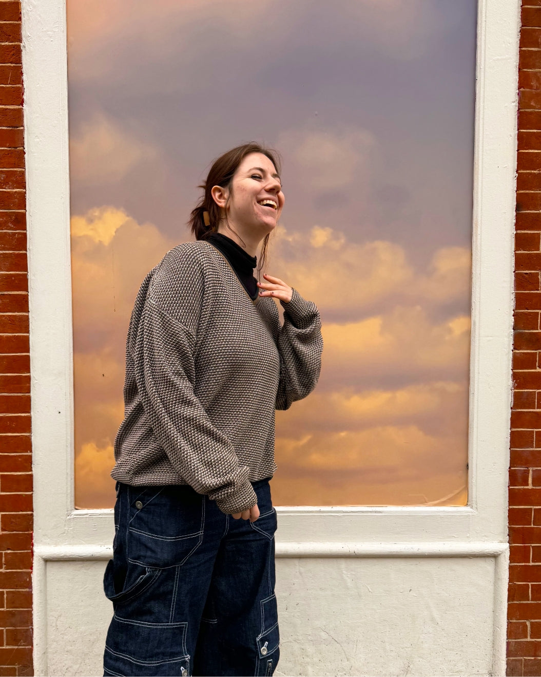 Milk Makeup Intern Chloe Zelch poses in front of a sunset image