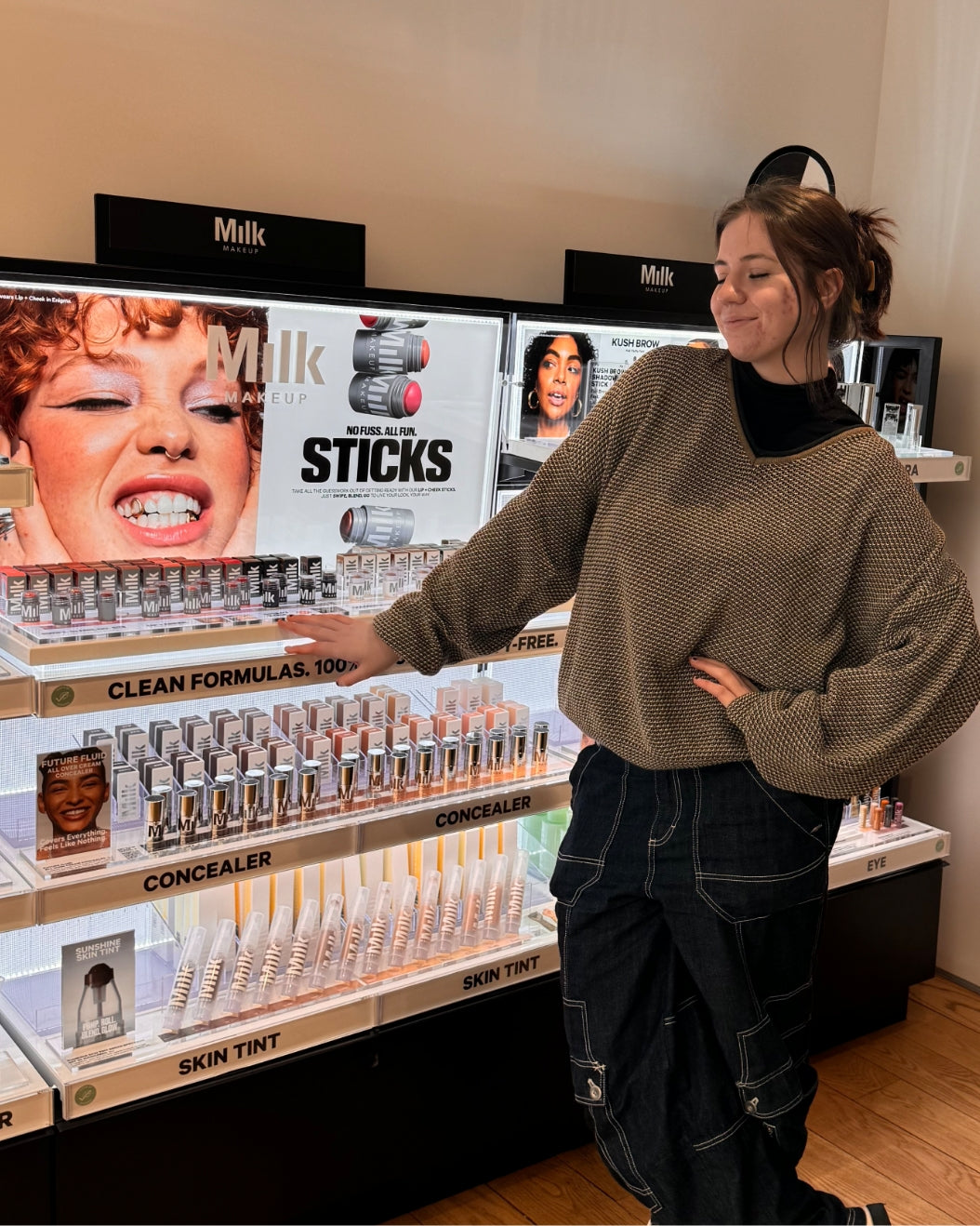 Milk Makeup Intern Chloe Zelch poses next to a Milk Makeup display.