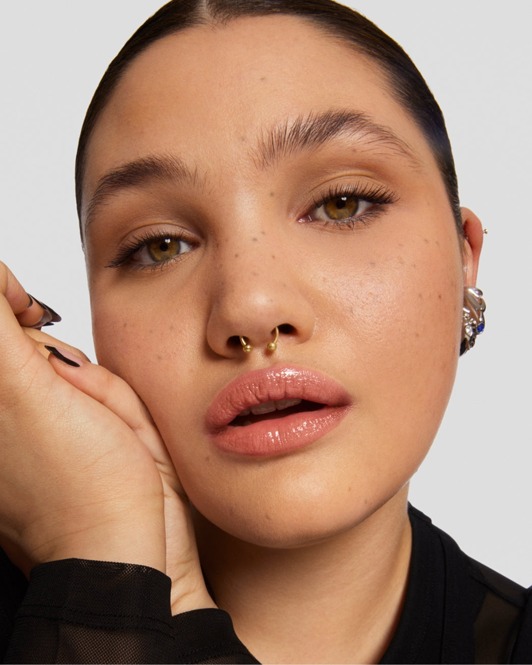 Portrait of a model wearing Milk Makeup RISE Waterproof Mascara on a white background.