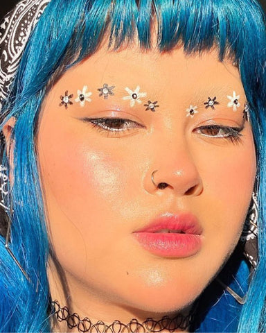 Model wears a makeup look with tiny flowers painted