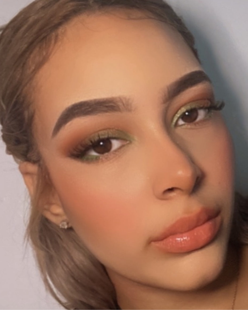 Selfie of a makeup artist with green and brown matte earth tone eyeshadows set with Milk Makeup Hydro Grip Set + Refresh Spray.