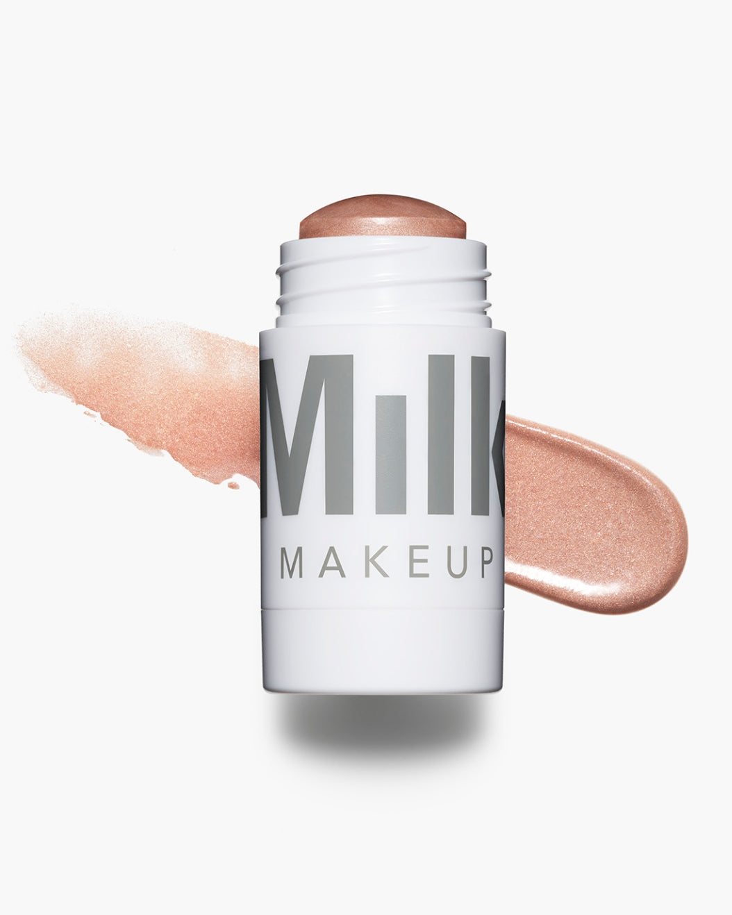 Product shot of Milk Makeup Highlighter in Flare (rose gold) with a swipe behind it against a white background.