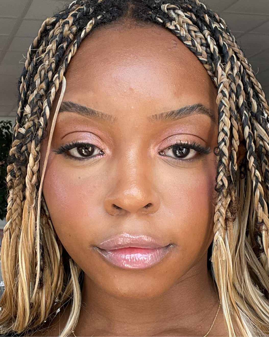 Woman wears a Y2K-inspired pink makeup look with Milk Makeup Odyssey Lip oil Gloss in Soul Search.