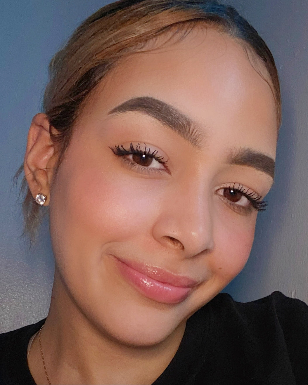 Makeup artist wearing a makeup look with defined, fluffy brows for a back-to-school makeup look.