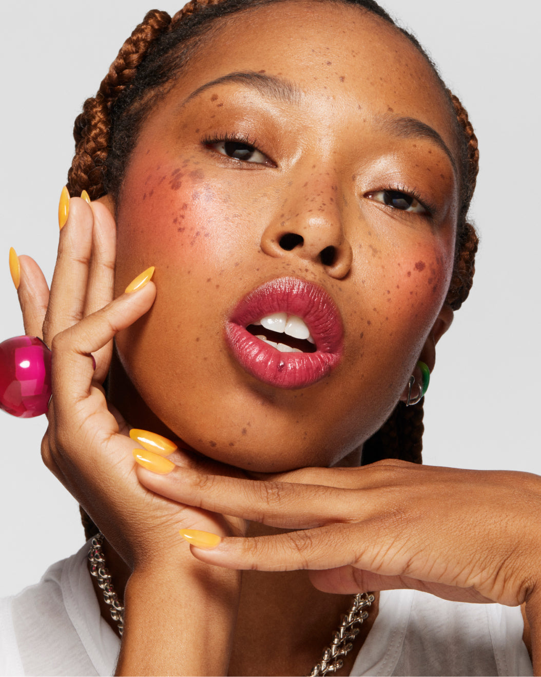 Portrait of a model wearing Milk Makeup Cooling Water Jelly Tint in Burst against a white background.