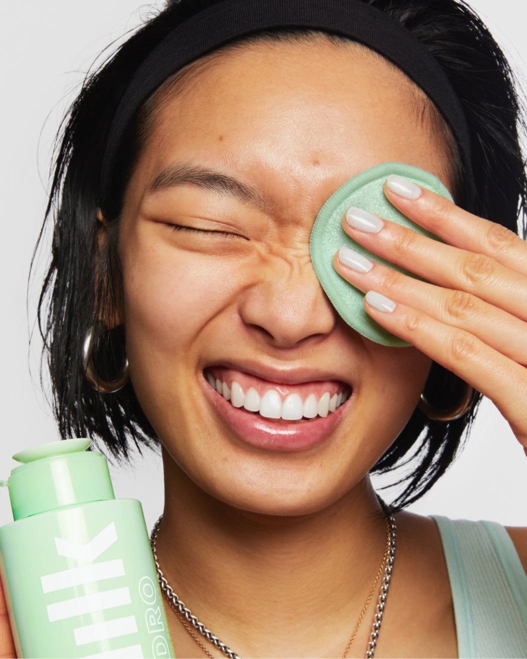 Model removes her makeup with Milk Makeup Hydro Ungrip Makeup Remover + Cleansing Water and a reusable makeup pad