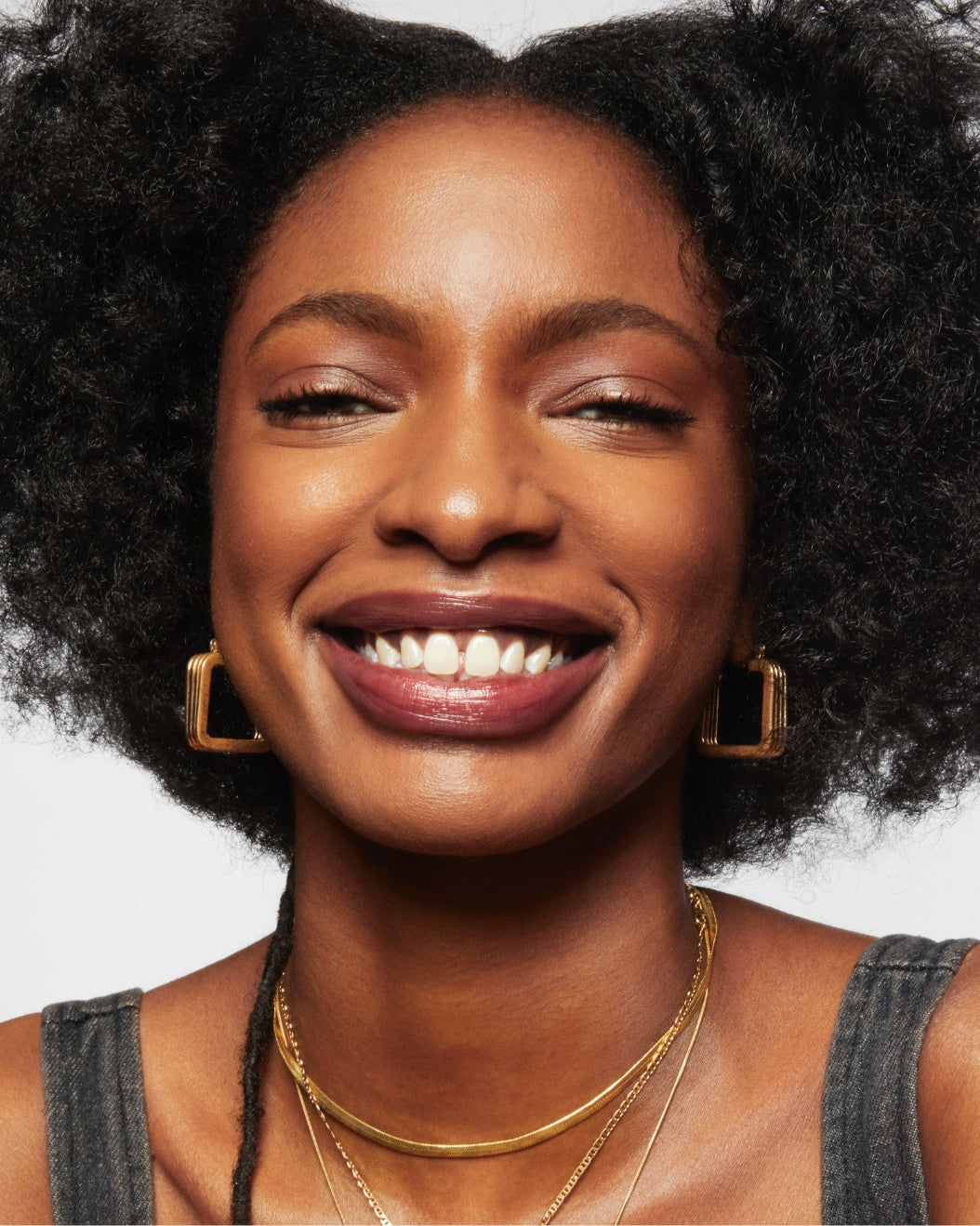 Portrait image of Milk Makeup model Ada smiling against a white background