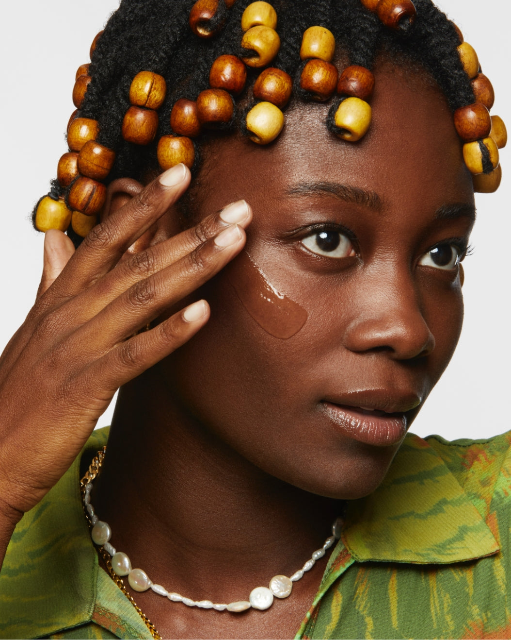 A model applies Milk Hydro Grip Primer on her cheek