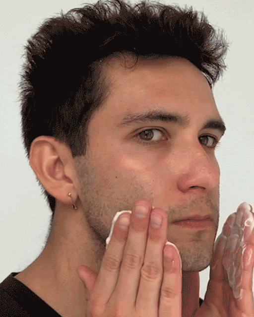 Model applies Milk Makeup Vegan Milk Cleanser to his face, then uses a razor to shave.
