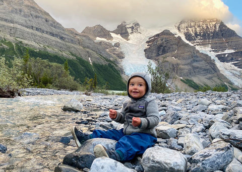 baby in Patagonia hoodie sitting in front of Mt. Robson