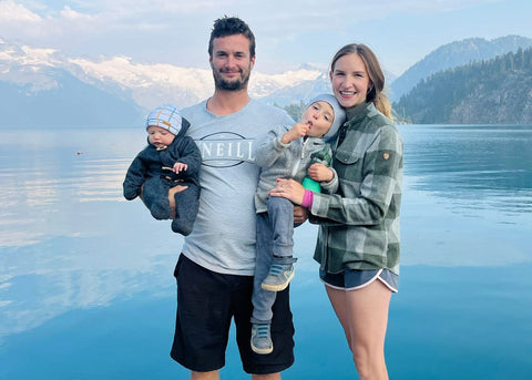 outdoor family of four standing in front of a lake