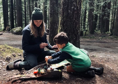 young mother playing with her toddler in a forest