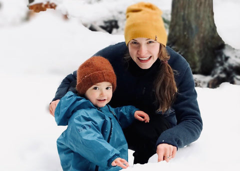 young mother with her toddler posing for the camera in a snow