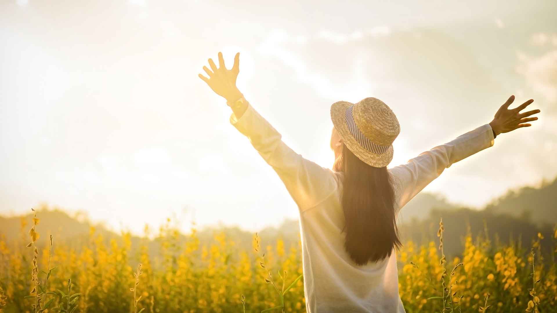 woman with spread arms under the sun vitamin D