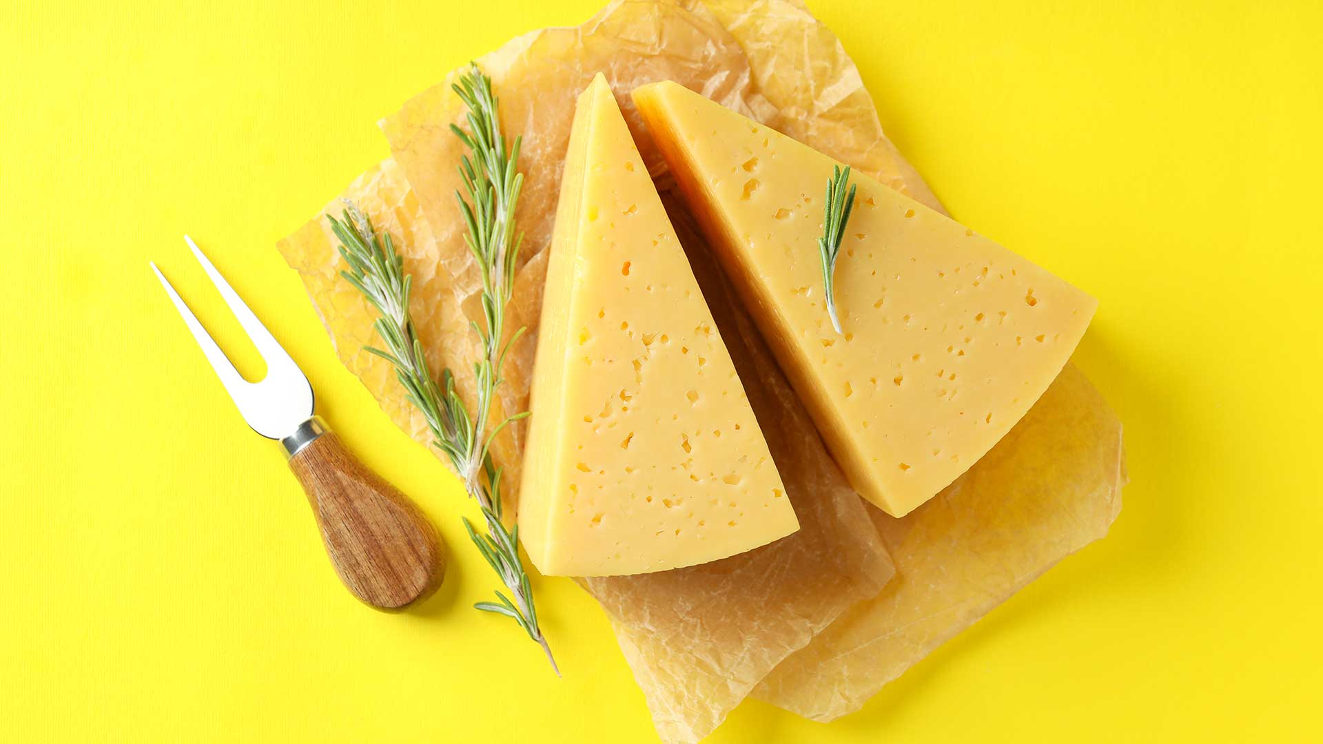 Two parmesan cheeses with rosemary garnish. 