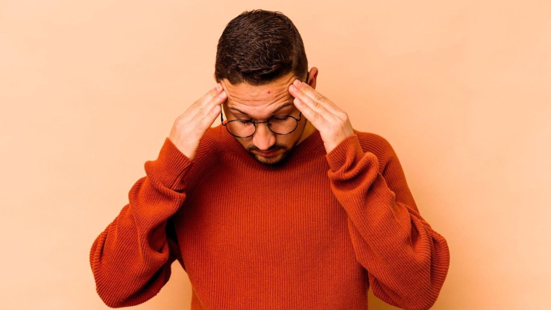 Man wearing a sweater having a headache