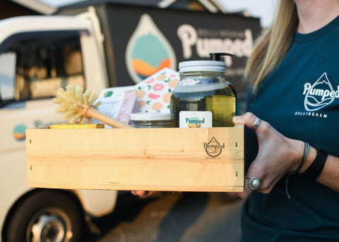 Image of hands holding wooden crate with sustainable home and self-care goods