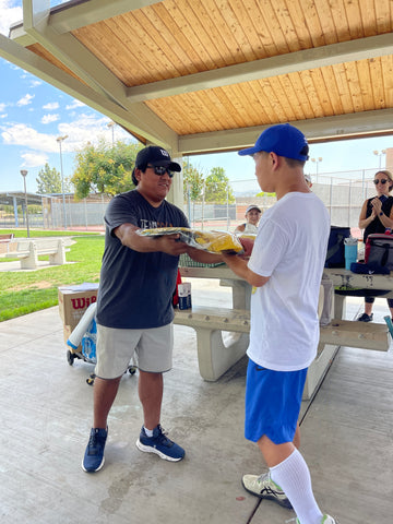 USTA official handing Serving Advantage athlete, Evan, a prize bag.