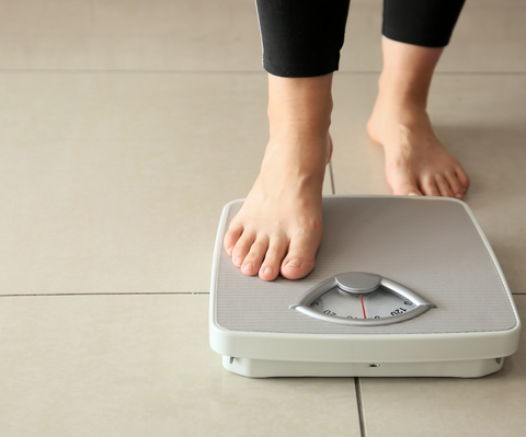 woman stepping on weighing scale