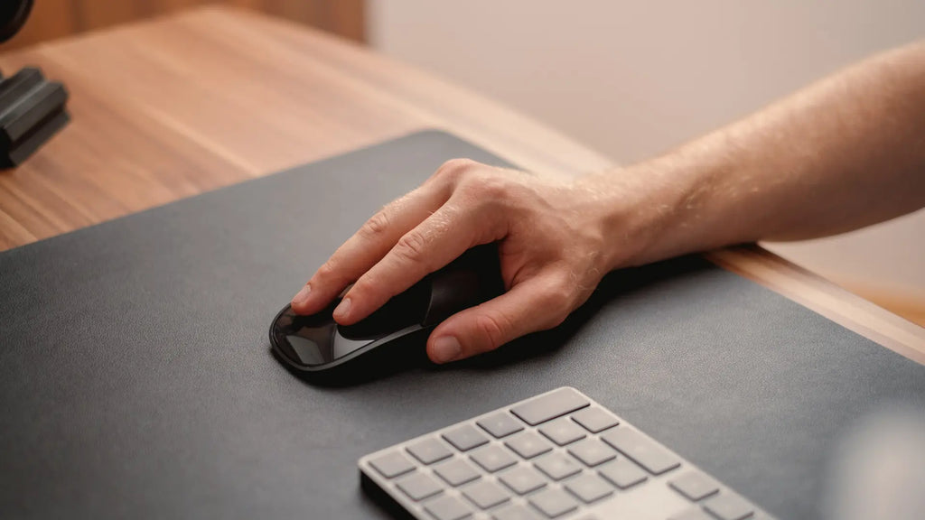 hand on a magic mouse with solumics case
