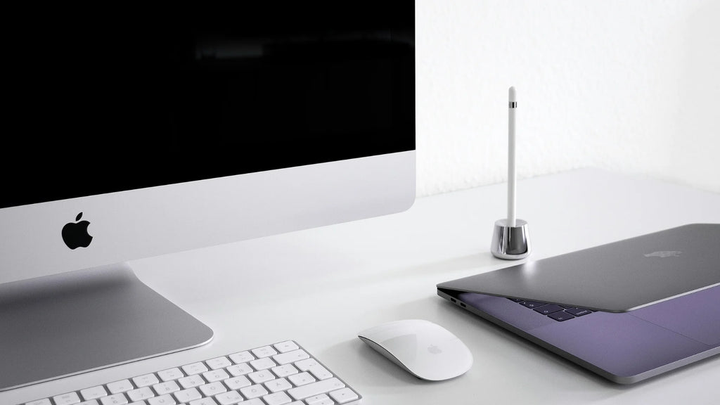 A workdesk with an apple magic mouse, imac and macbook