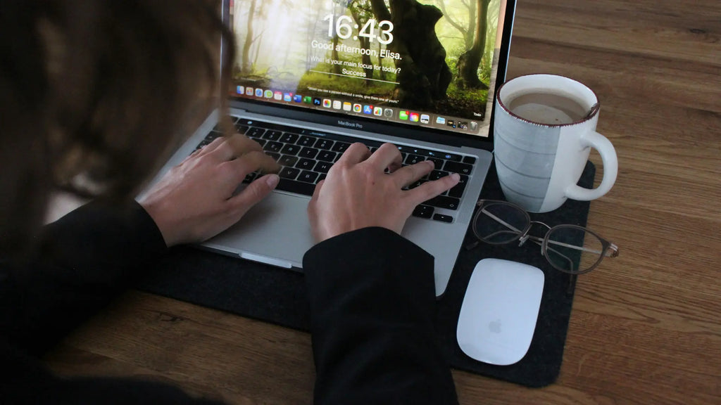 Apple User working on a macbook with a magic mouse