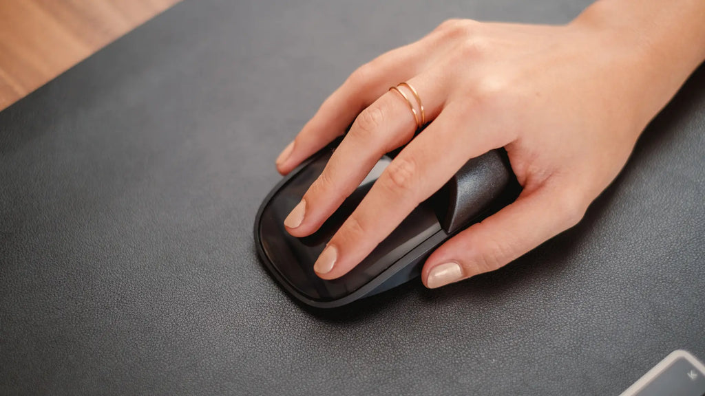 hand on a magic mouse with the solumics case