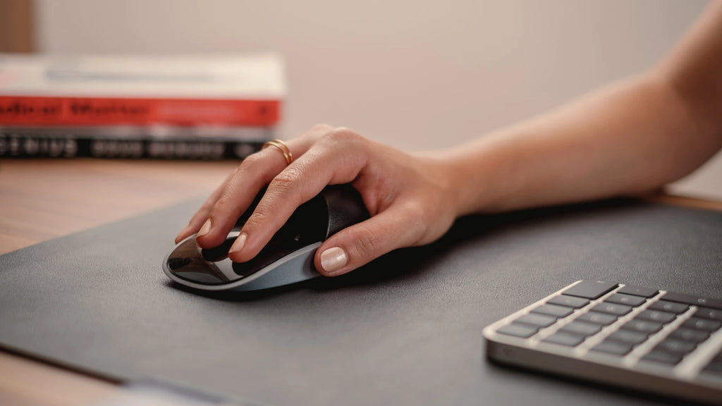 hand on a magic mouse with the solumics case